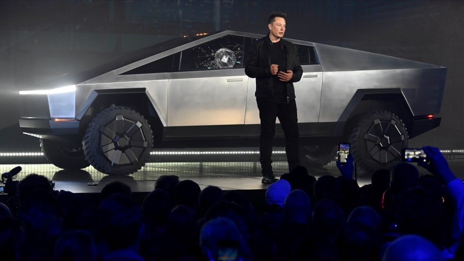 Elon Musk standing in front of the newly released cybertruck with broken glass after the product failure. 